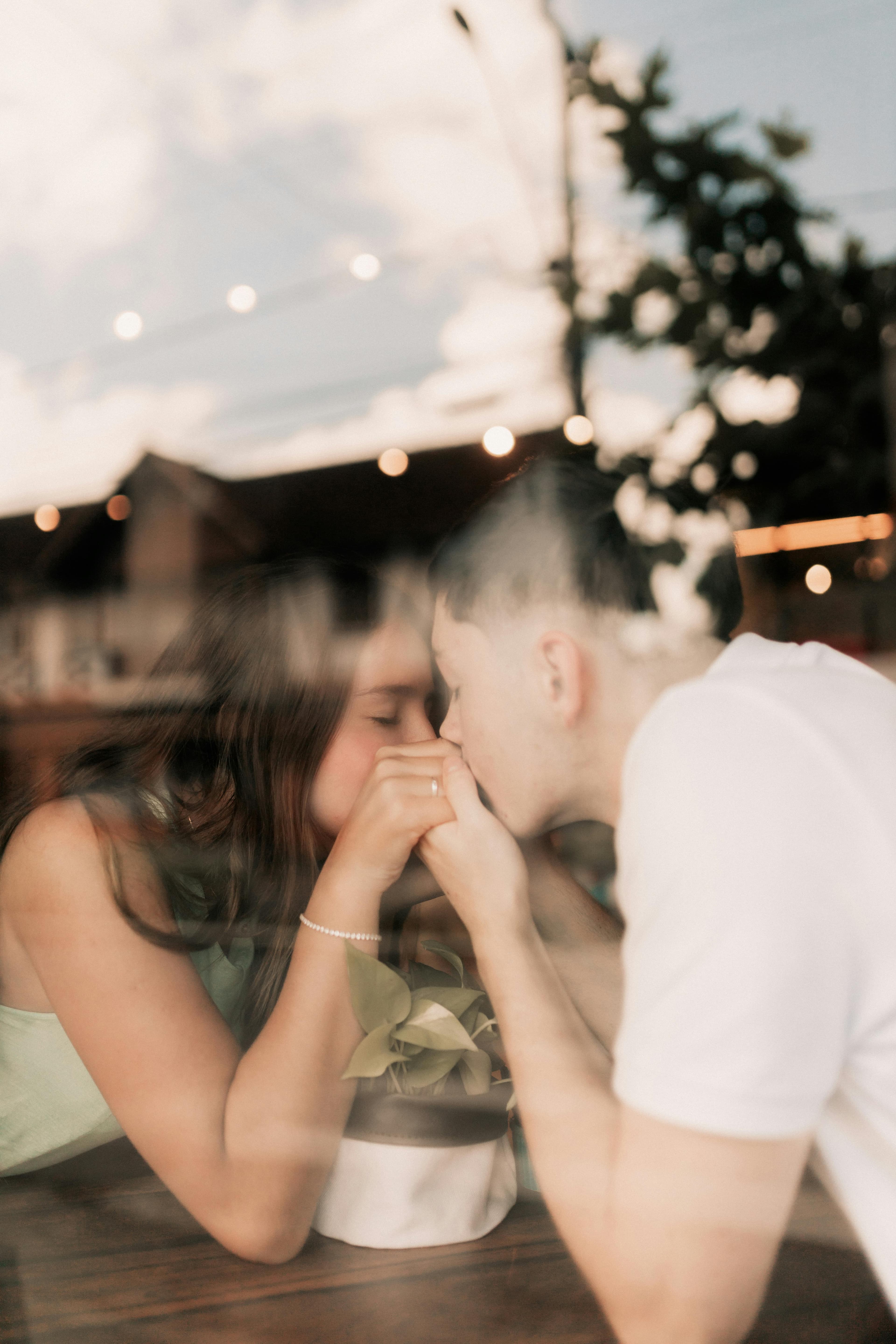 Intimate close-up of a couple leaning toward each other across a table